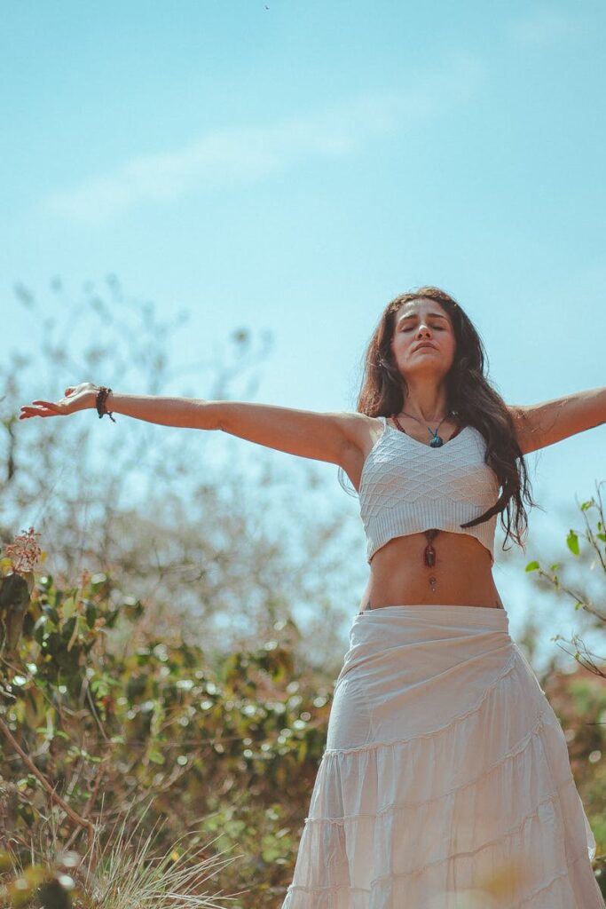 Peaceful scene of a woman meditating outdoors in a sunny summer setting, embodying wellness and tranquility.